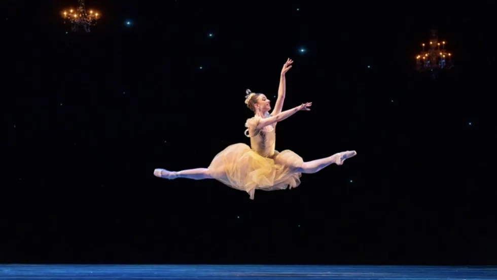 Julia Rust performing a grand jeté on stage